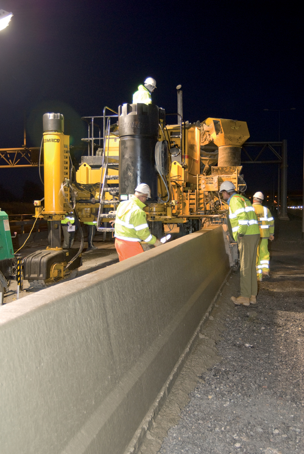 Slipformed concrete barriers being installed