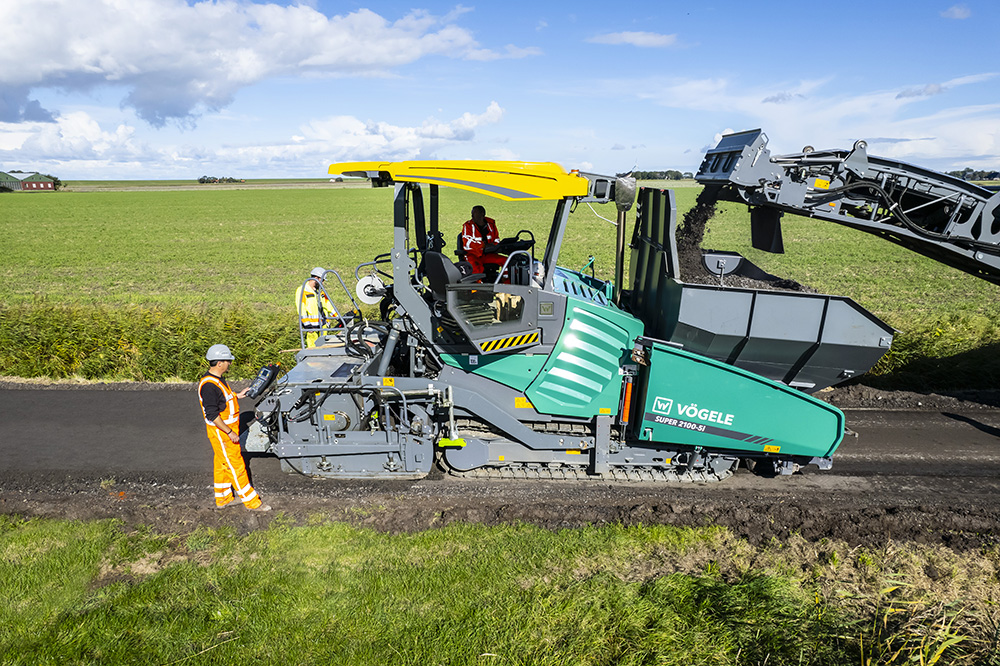 Latest-generation powerful Vögele paver: the SUPER 2100-5i can take up to 20 tonnes of material with an extra material hopper and pave up to 1,100 tonnes per hour.