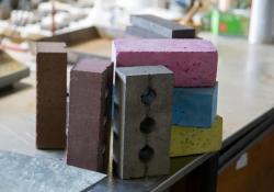 A novel brick is now offered that is made from waste materials